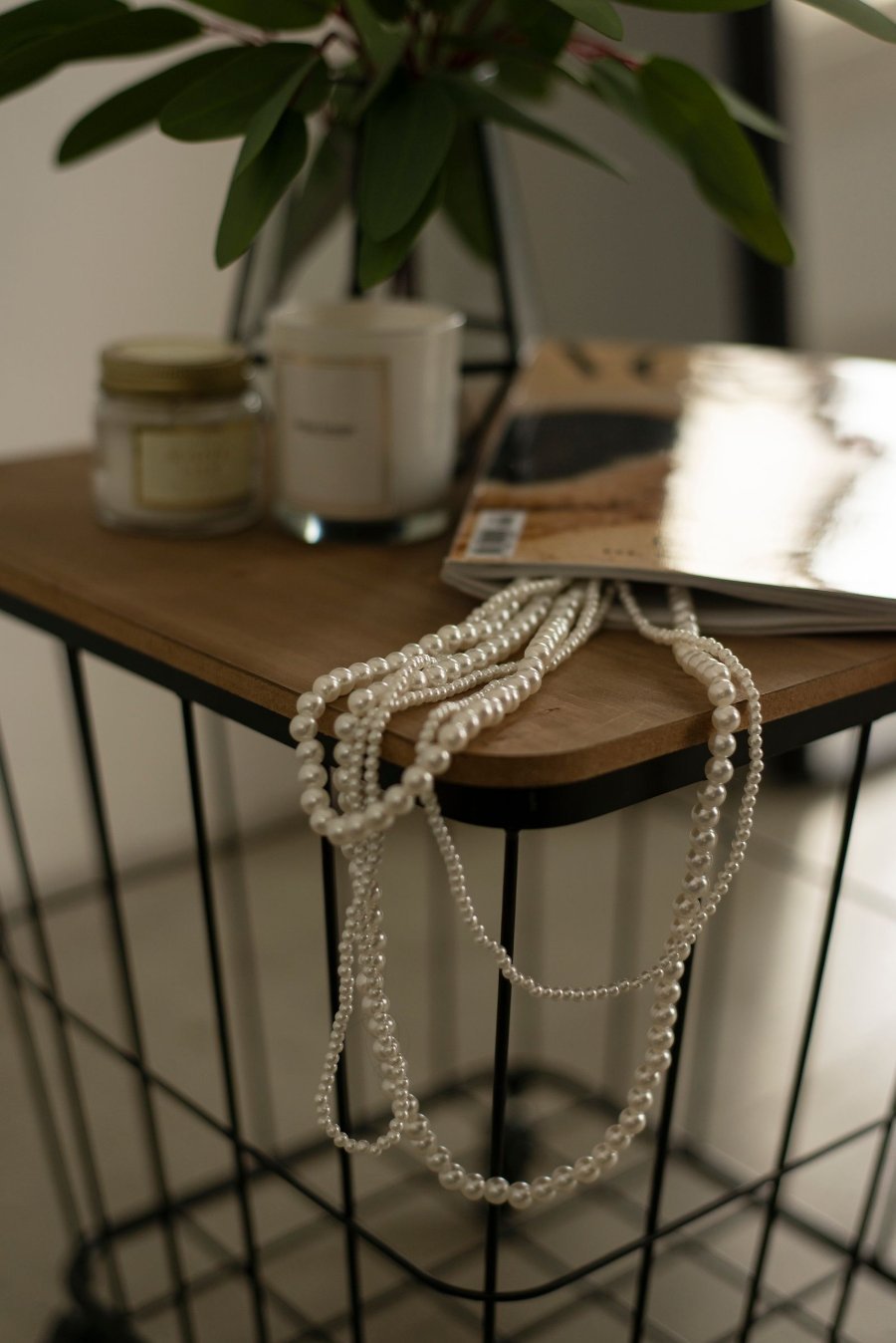 Strands of pearl necklaces draped over a small table