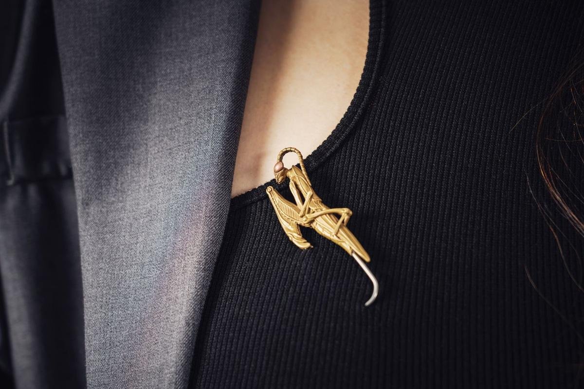 Gold brooch pinned to a dark jacket