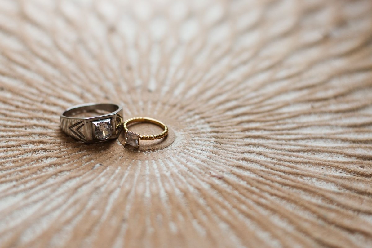 Two rings resting on a textured wooden surface