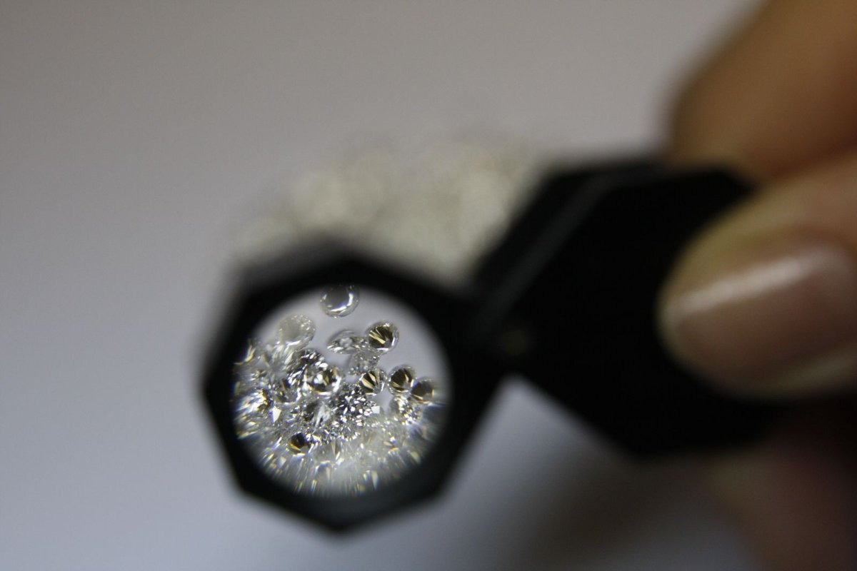 Jeweler's loupe resting over small loose stones on a work surface