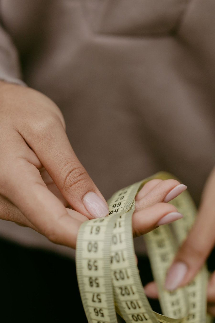 Hands holding a cloth measuring tape